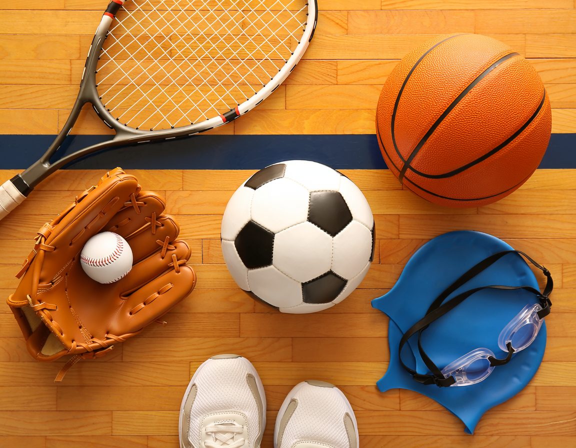 Tennis racket, baseball glove, soccer ball, basketball, swim cap and goggles on a gym floor